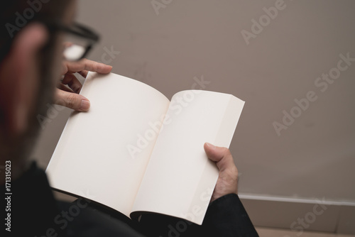 Blank spread, open book in man's hands