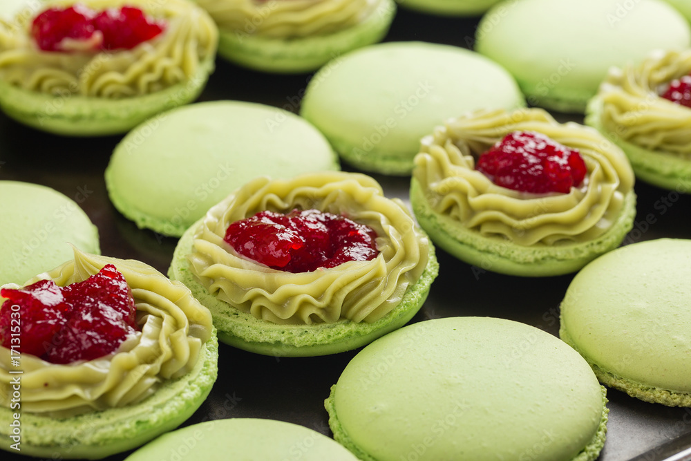 Green macaroons with pistachios ganache cream and raspberries confit filling