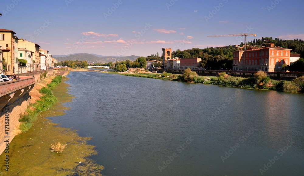 Blick auf die idyllische Wohngegend am Ufer des Arno mit Brücke im Hintergrund