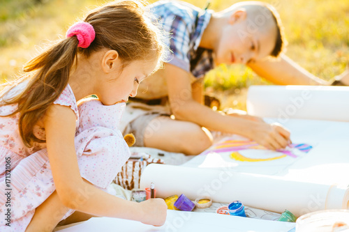 Portrait of two children painting, summer outdoor. Art, drawing and kids creativity concept.