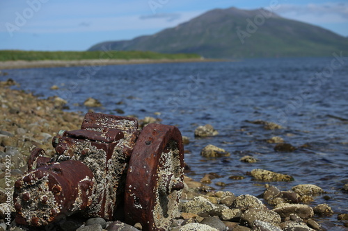 Ship parts sit upon the rocky shores in False pass, Alaska.