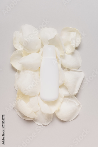 bottle of lotion on petals