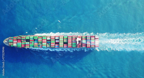 Mega huge fully loaded container ship at sea aerial top down