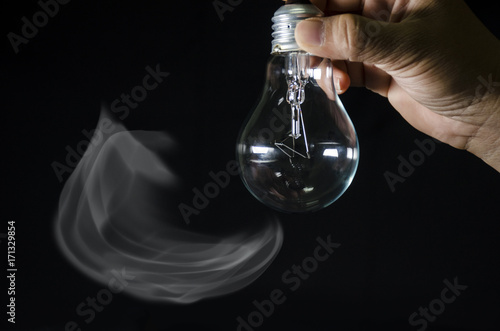 bulb light in human hand and black background 