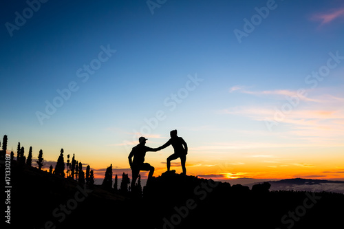 Teamwork couple climbing with helping hand