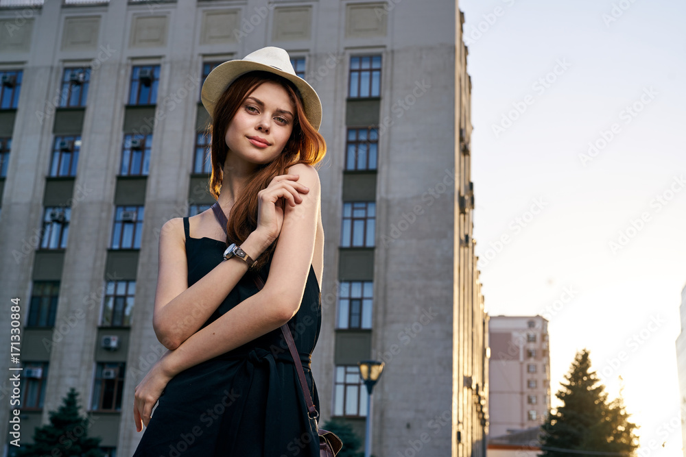 woman in a hat in a city by a large building