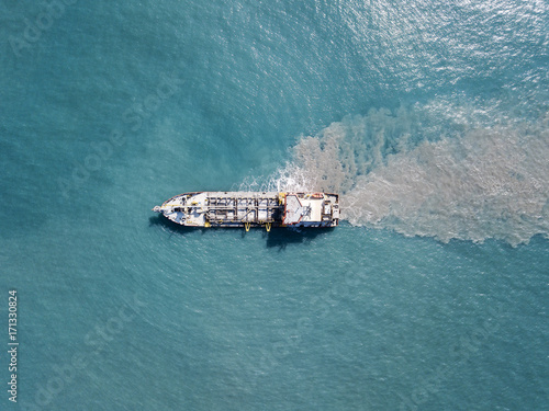 Suction Dredger ship working near the port - with mud, Pollution, brown Muddy water - aerial tip down shot
