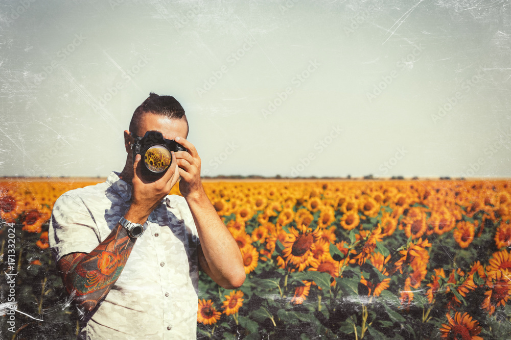 Portrait Of Male Photographer Making Photo With Camera In Hands Outdoors On Sunflowers Field