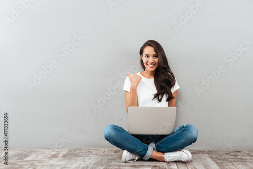 Happy smiling asian woman working on laptop computer