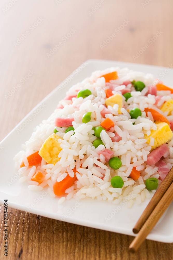 Chinese fried rice with vegetables and omelette on wooden table
Chinese fried rice with vegetables and omelette on wooden table