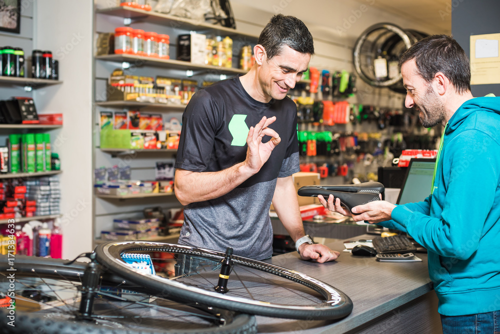 Man is buying a bike wheel in a special workshop