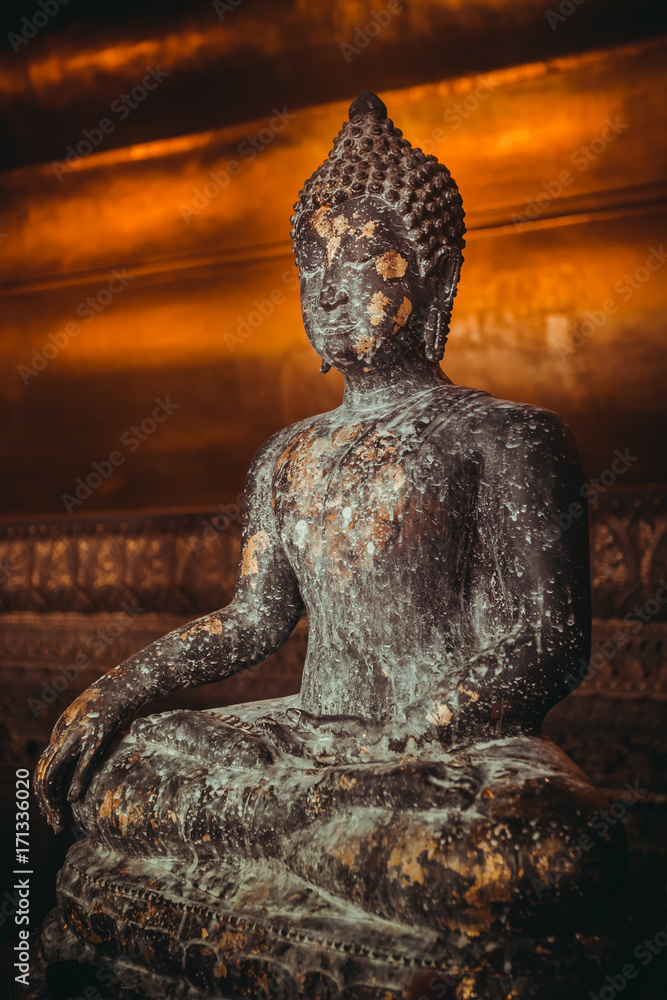 Fototapeta premium Stone statue of Buddha sitting in lotus pose gold-plated. Thailand, religious temple attraction