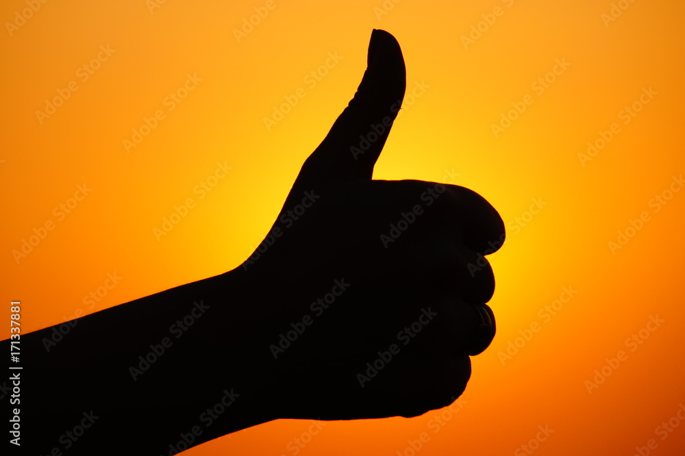 Thumb up, cool gesture, hand sign, silhouette of a hand on the sunset