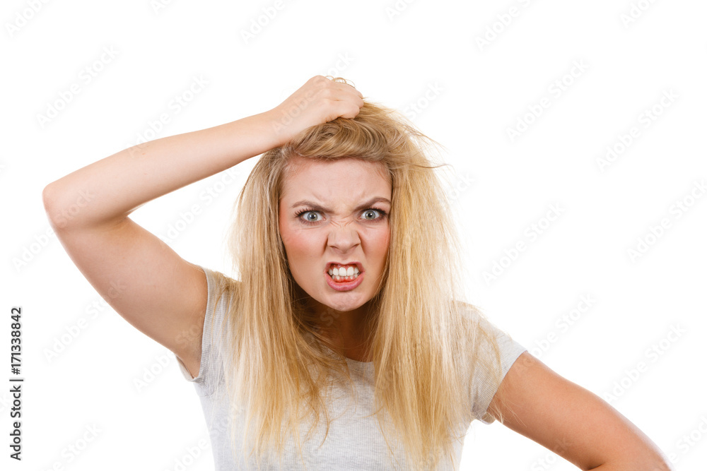 Furiously mad angry blonde woman holding hair Furiously mad angry blonde woman holding hair