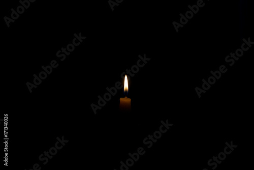 Small candle burning in the dark