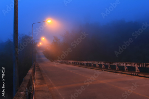 perspective landscape concrete road bridge with lamppost in night time and mist weather cold