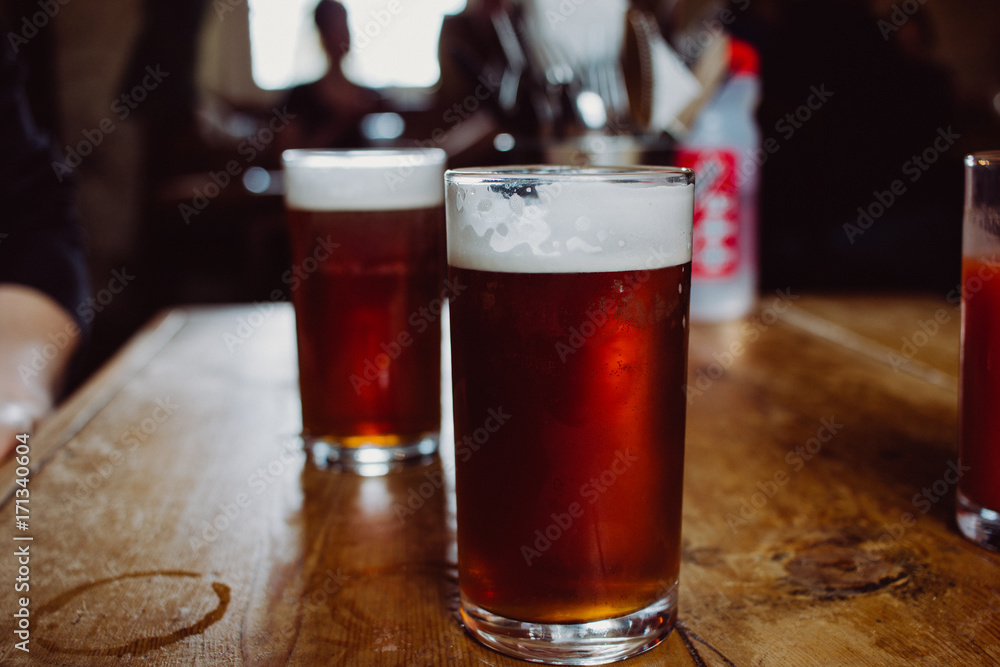An english ale bitter beer pint on a wooden table in a pub in UK An english ale bitter beer pint on a wooden table in a pub in UK