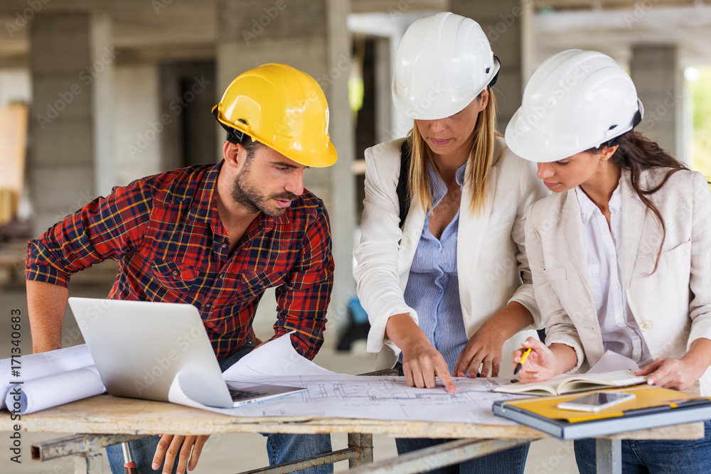Two female inspectors and architects discuss with
head engineer about construction project. Two female inspectors and architects discuss with
head engineer about construction project.