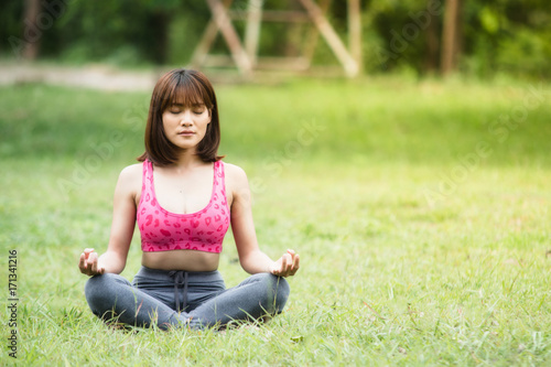 Young girl doing yoga on green grass,Concept of healthy lifestyle and relaxation.