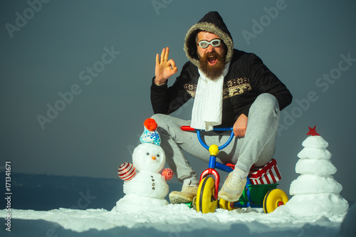 Fotografia Happy man riding tricycle on grey sky