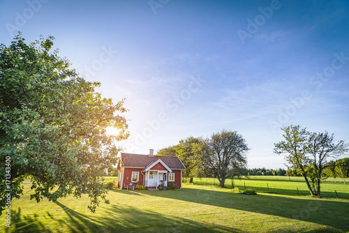 Schilderij op canvas Small red house on a swedish countryside landscape