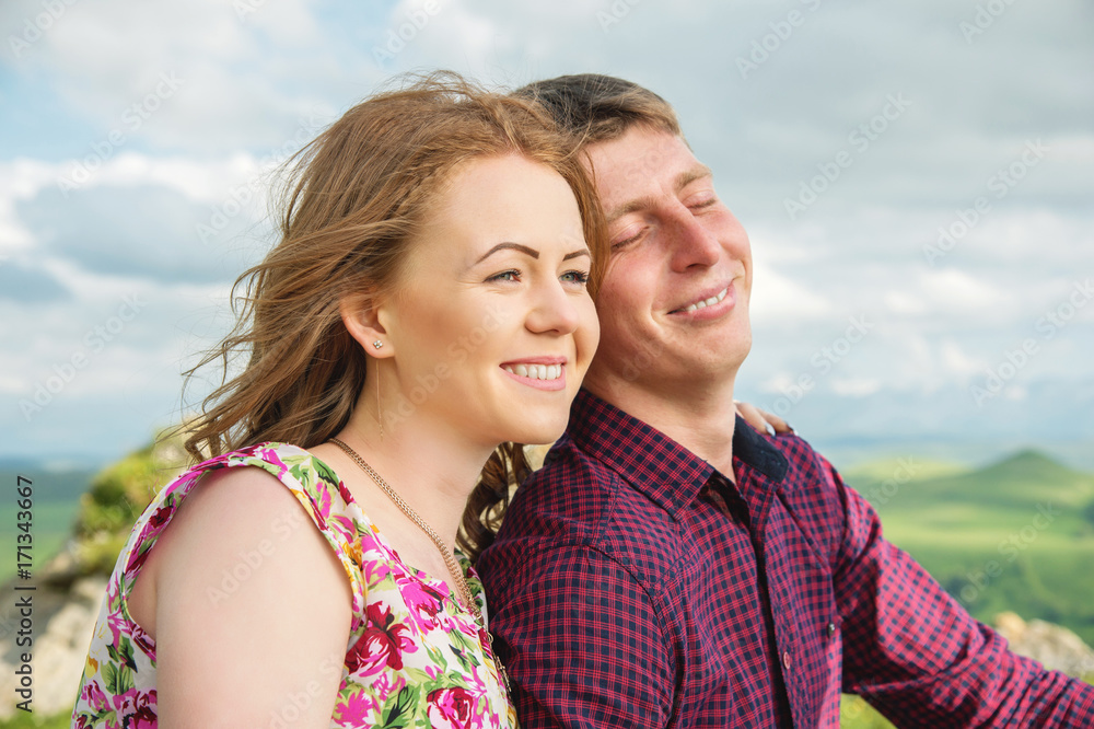 Young married couple laughing happily in nature against the background of rocks and stones Young married couple laughing happily in nature against the background of rocks and stones
