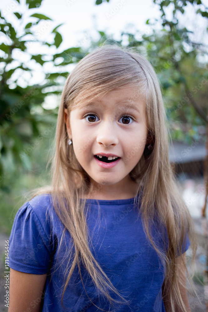 Young little girl without a front tooth in the countryside Young little girl without a front tooth in the countryside
