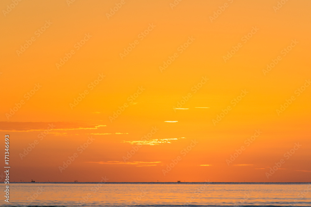 Beautiful golden sunrise and fishing boat at beach in Thailand. Dawn light with golden reflection on beach landscape.
