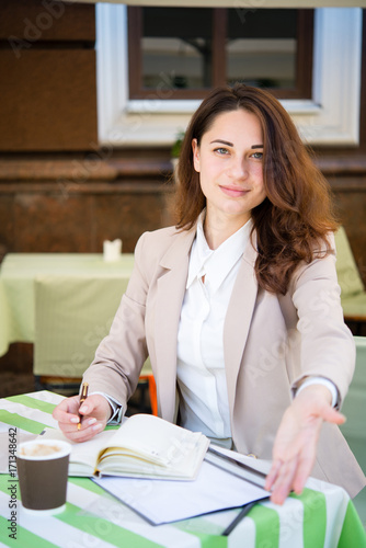 business girl invites to a conversation in the summer cafe