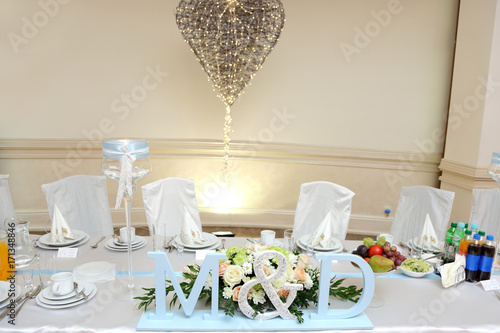 Stół weselny z bukietem róż, miejsce dla pary młodej.