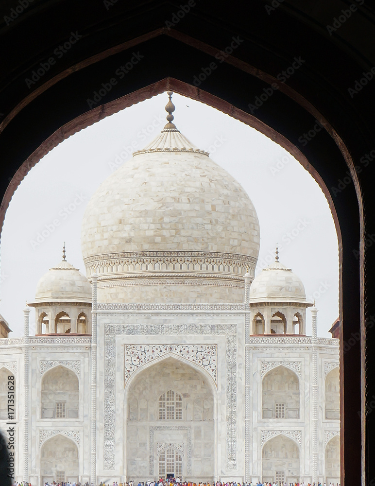 The famous monument of Taj Mahal as seen through the arched entry gate. This is a landmark and a popular tourist destination