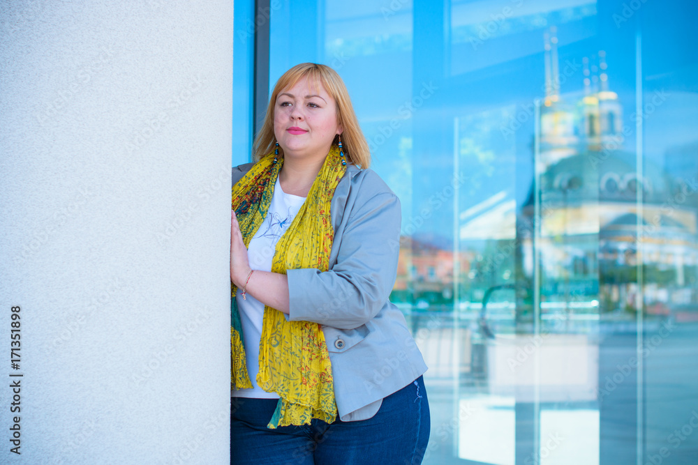 Young stylishly dressed blonde hair woman, plus size walk on the town streets. The concept of harmony and life in a big city for large people Young stylishly dressed blonde hair woman, plus size walk on the town streets. The concept of harmony and life in a big city for large people
