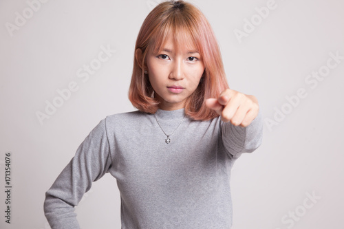 Young Asian woman angry and point to camera.