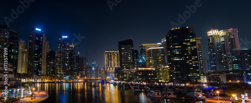 Panorama of illuminated skyscrapers with reflection in water night
