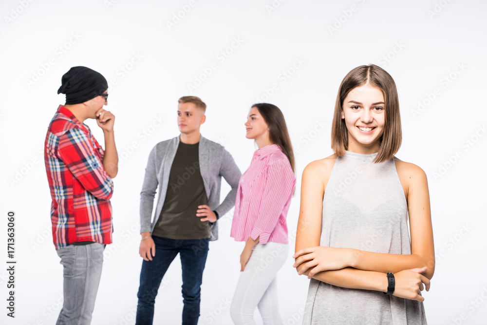 Confident in her beauty. Cheerful young woman keeping arms crossed and smiling while her friends talking on background Confident in her beauty. Cheerful young woman keeping arms crossed and smiling while her friends talking on background