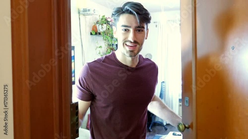 Young handsome man welcoming someone in his house, seen from the point of view, POV, of the person entering