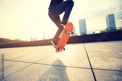 Woman skateboarder skateboarding at sunrise city