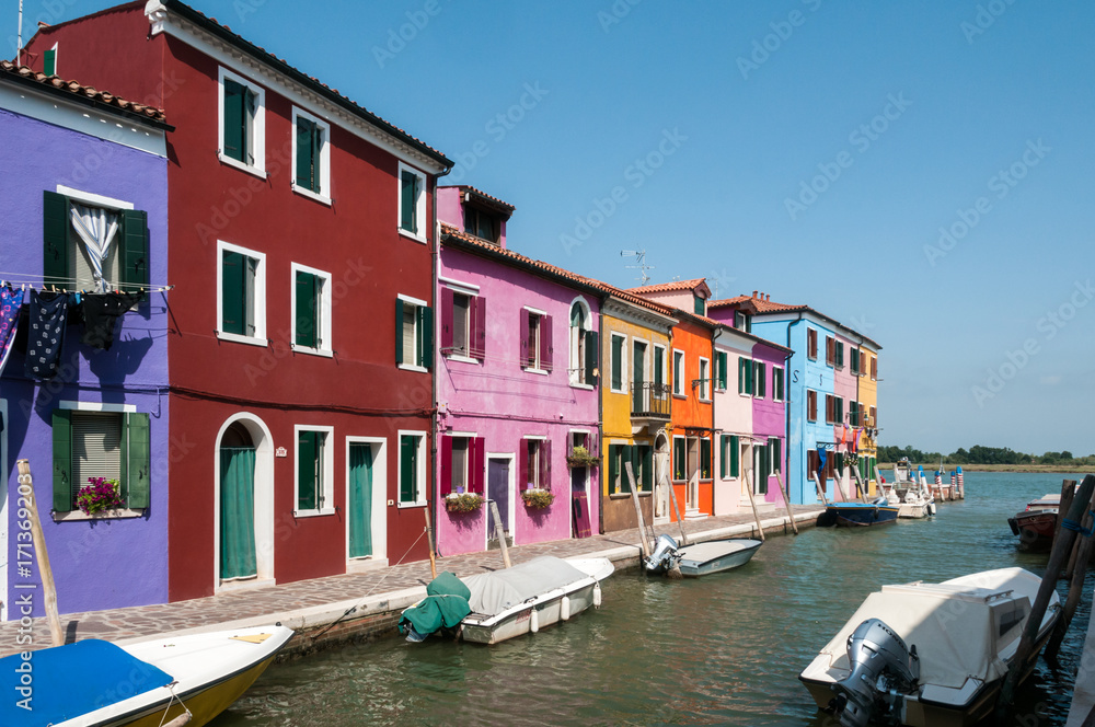 Rainbow of colorful homes on a canal in Burano, Italy