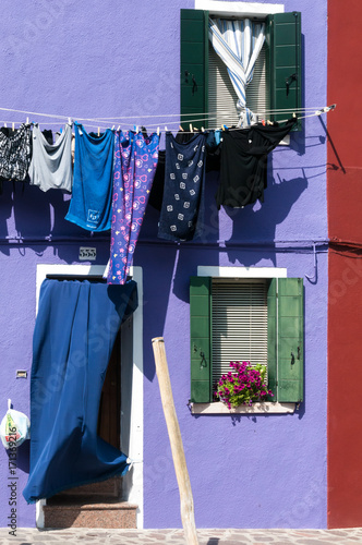 Blue laundry hanging to dry outside a purple house