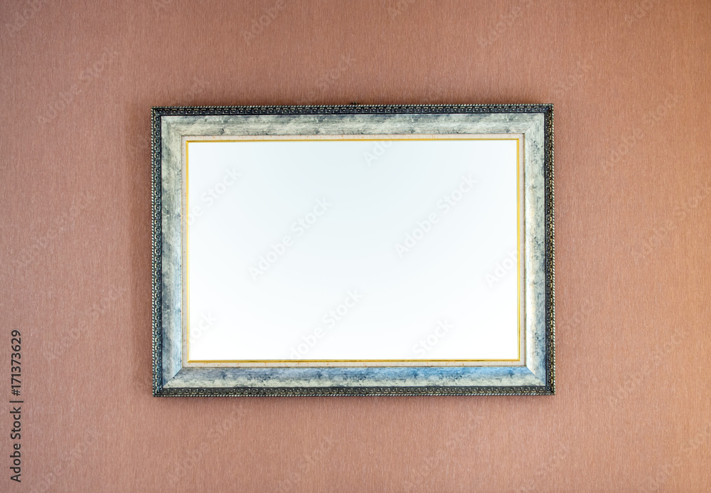 The blank ornate picture frame on the wall