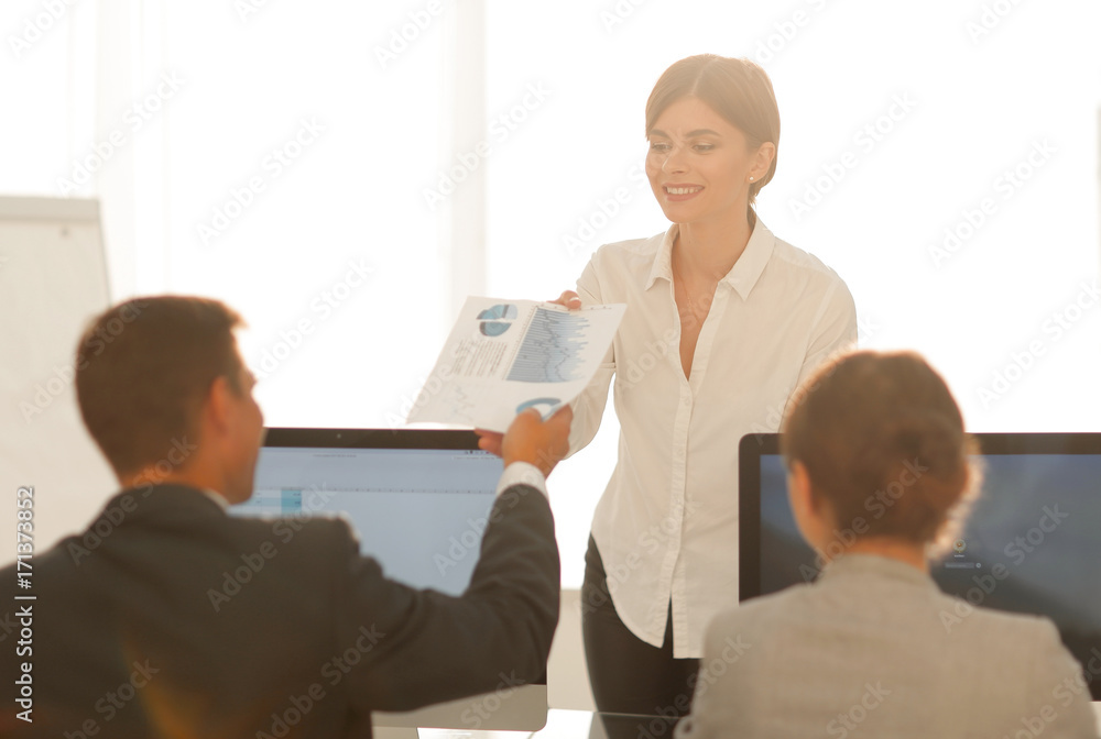 senior Manager, handing the employee a document with financial data. senior Manager, handing the employee a document with financial data.