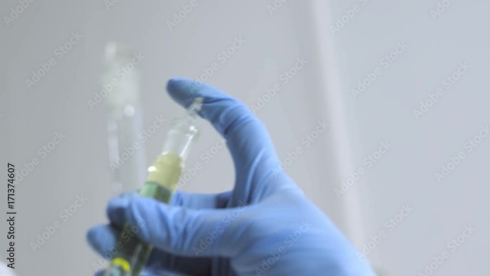 A laboratory assistant in gloves is mixing snake poisons A laboratory assistant in gloves is mixing snake poisons