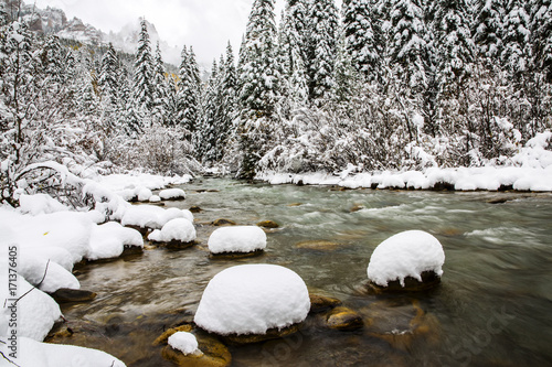 snow covered rocks in a cold mountain river 