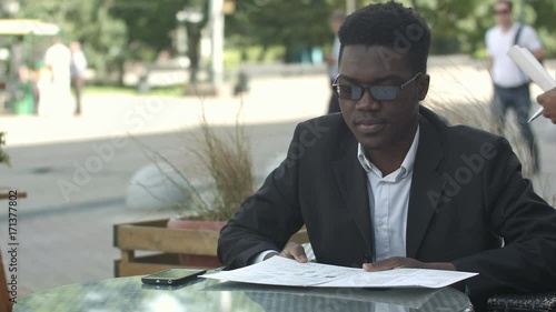 Afro american business man ordering in outside cafe photo