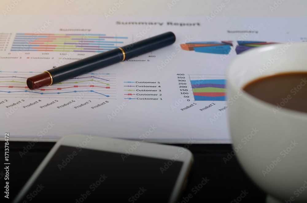 Workplace with charts, phone, coffee cup, on wooden table. Workplace with charts, phone, coffee cup, on wooden table.