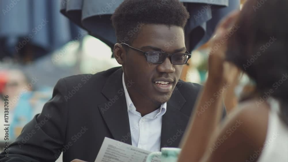 Afro-american businessman with his colleague reading menu in restaurant Afro-american businessman with his colleague reading menu in restaurant
