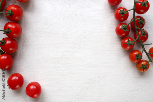 Bright red juicy tomatoes on white wooden background