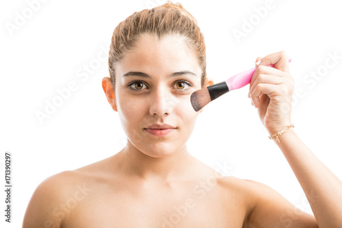 Young woman putting some makeup on