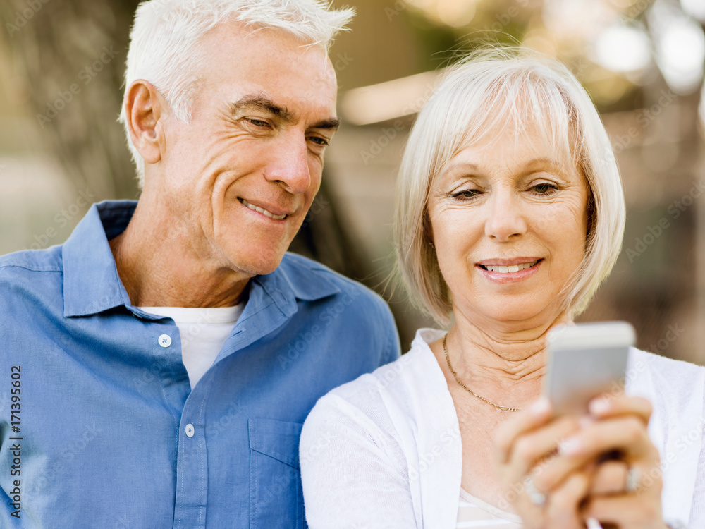 Happy senior couple looking at smartphone Happy senior couple looking at smartphone