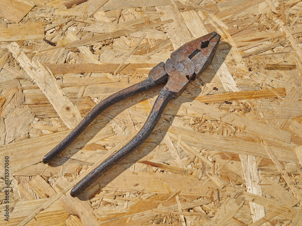 Pliers on a wooden background